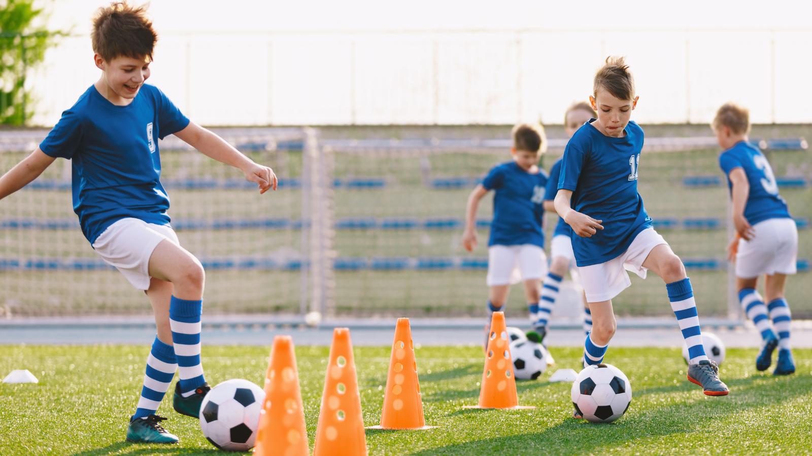 Děti při fotbalovém tréninku v barefoot dětských kopačkách na hřišti