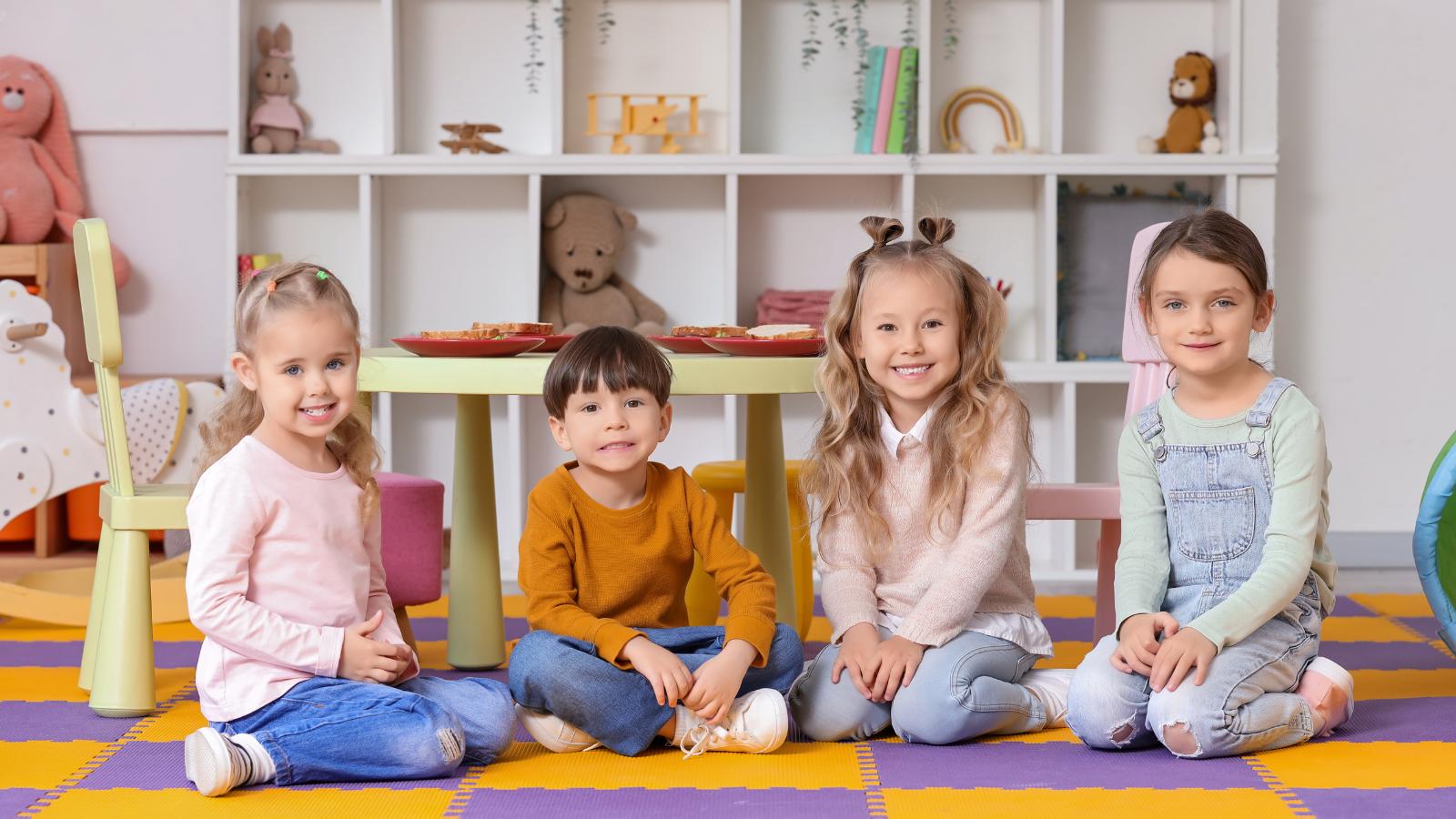 Děti ve školce v dětských bačkorách při hraní