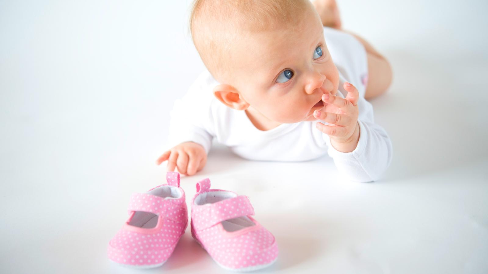Miminko s dětskými capáčky připravenými na první krůčky