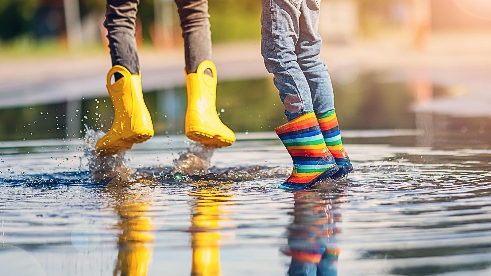 Děti skákající v louži v dětských holínkách